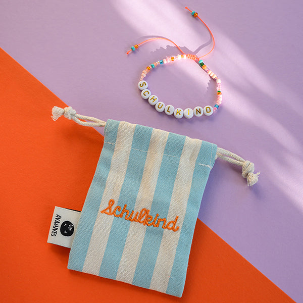 Perlenarmband SCHULKIND orange/rosa mit Buchstaben in gold inklusive blau gestreiftem, besticktem STOFFBEUTEL