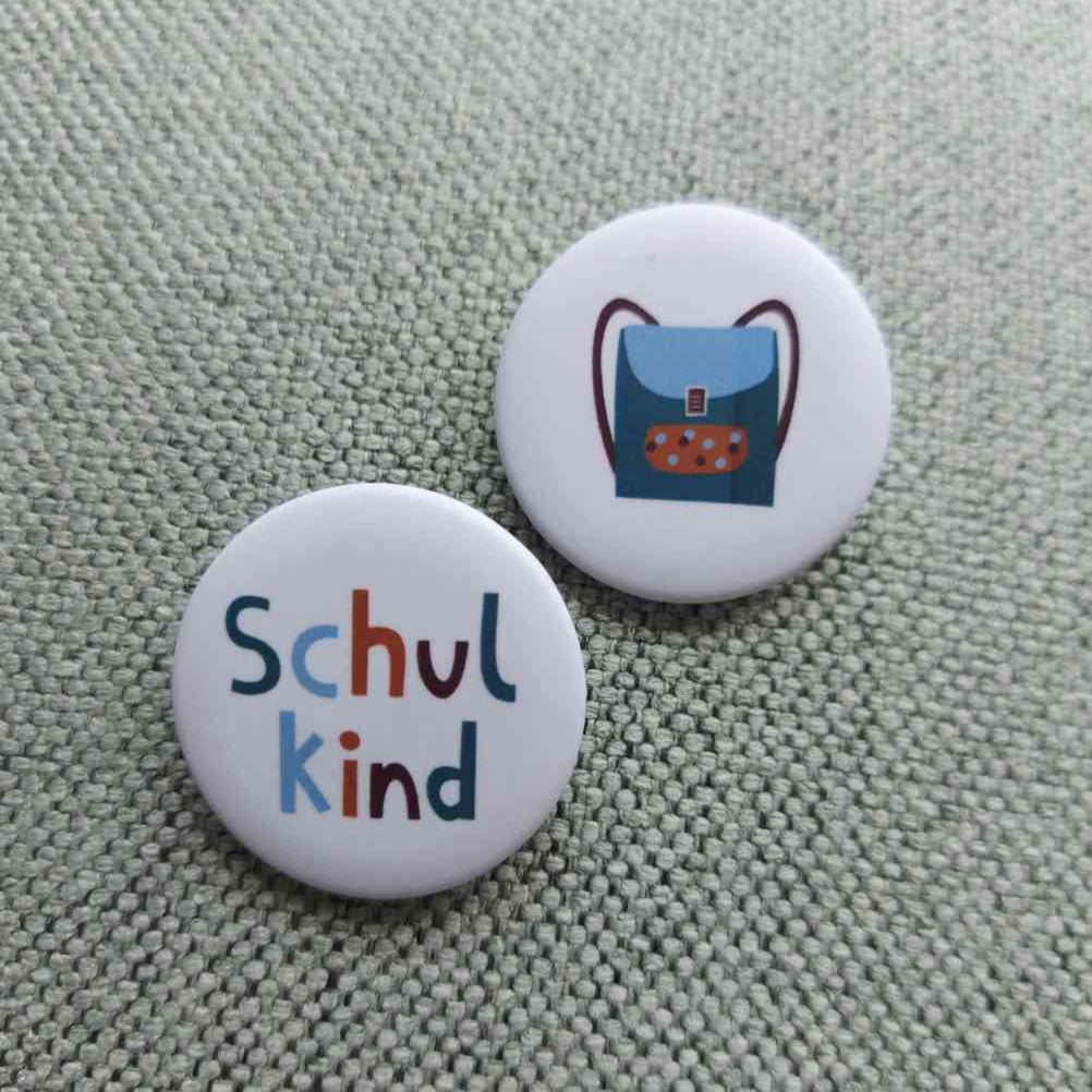 Schulkind Buttons 2er Set 1x als Schriftzug 1x als Schulranzen-Motiv, erhältlich bei www.luiseundfritz.de