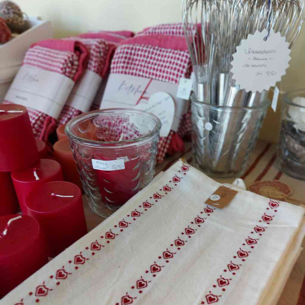 Geschirrtücher in der Farbstellung rot von Home Society und Ib Laursen, sowie Schneebesen von Ib Laursen und rote Stumpenkerzen und ein vielseitig verwendbarer Glastopf. Alles erhältlich bei www.luiseundfritz.de