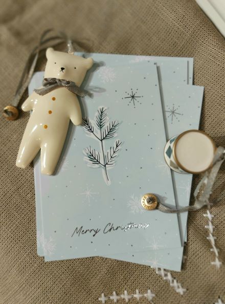 stimmungsfoto mit postkarten merry christmas einem maileganhaenger baer und einer maileg trommel bei luiseundfritz.de